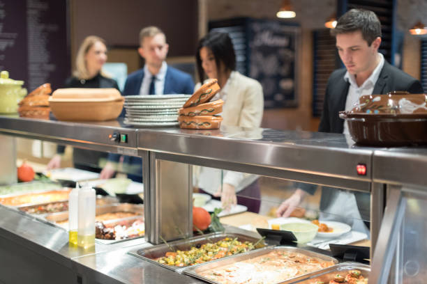 Group of business people in canteen during lunch time waiting in line